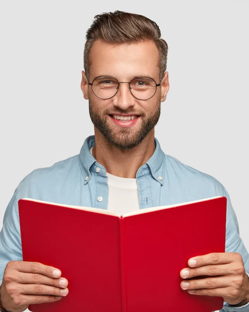 studio-shot-cheerful-man-reader-with-satisfied-expression-holds-red-book_273609-18571